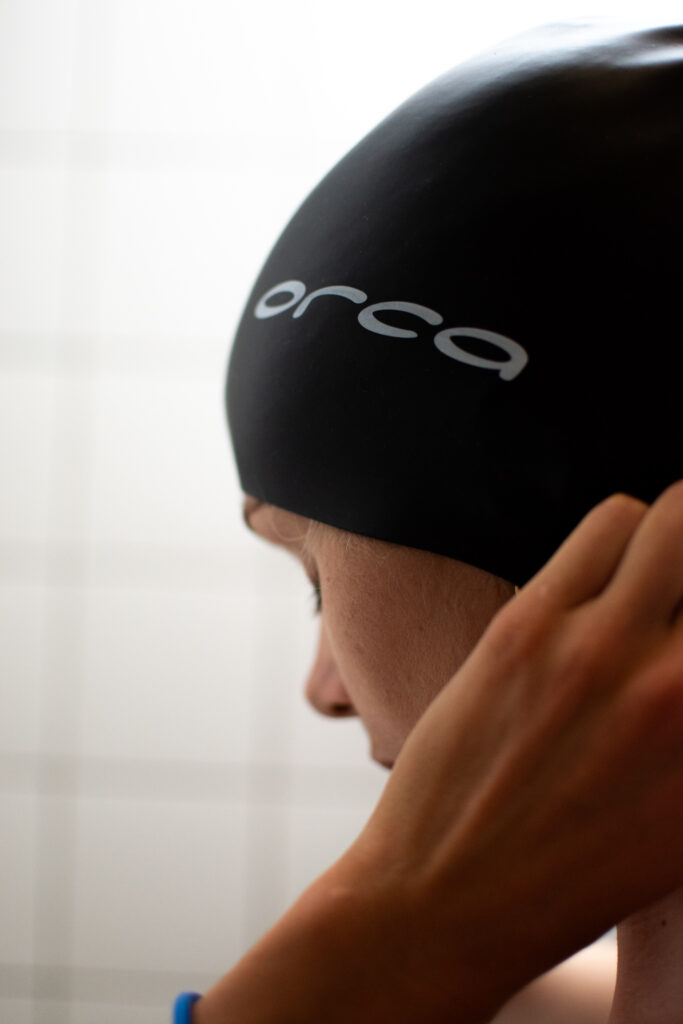 Atleta sujetando gorro de la marca de natacion Orca