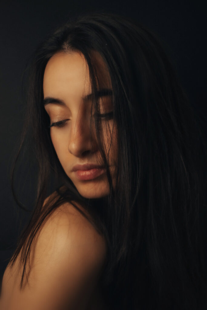 Retrato de mujer con mirada hacia el hombro desnudo